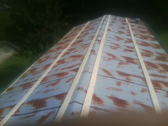 Rusted metal roof panels with new wood purlins before replacement — Storm Damage Roof Repair in Wadesboro by Roofing Brothers