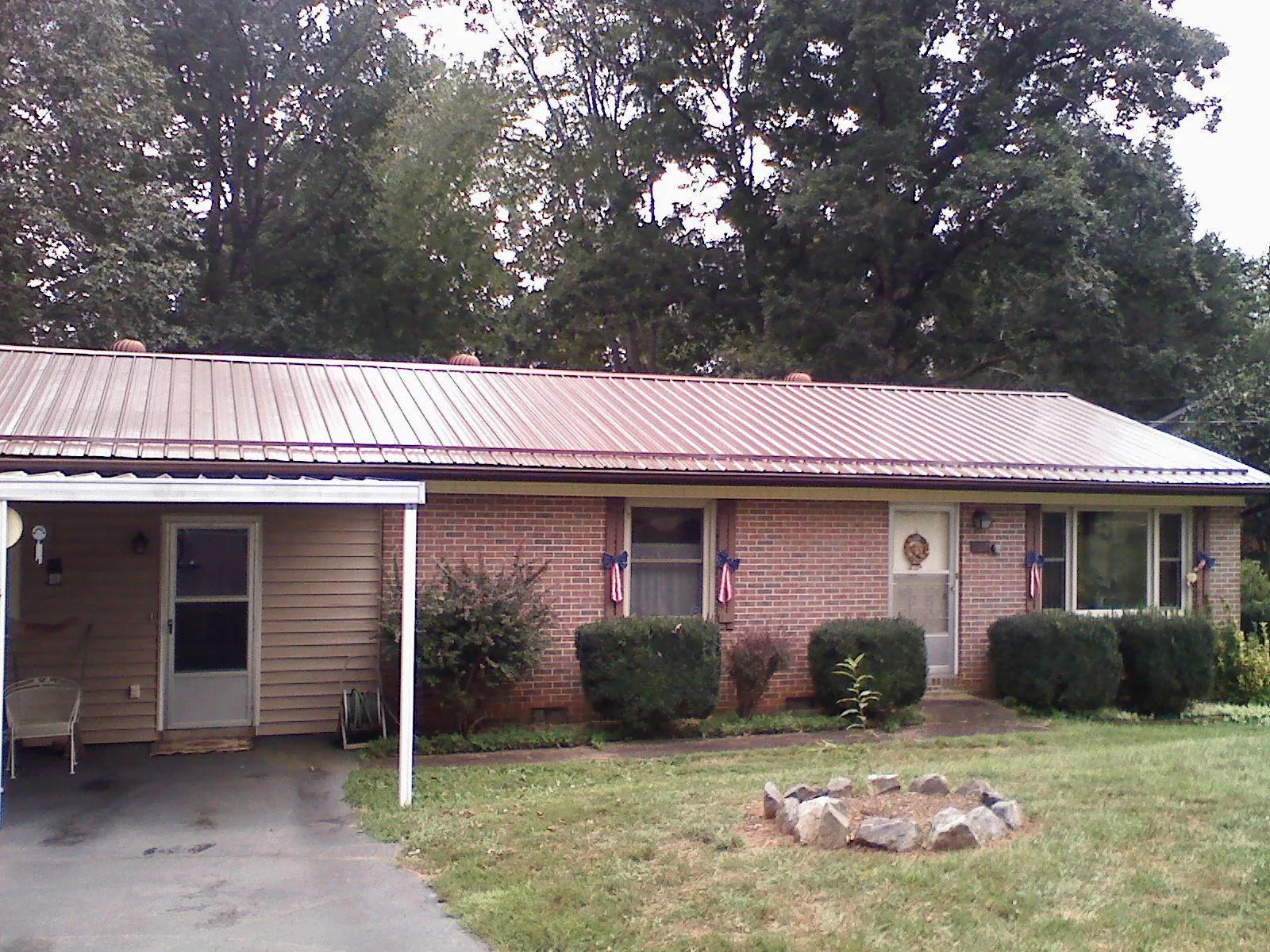 Bronze metal roof and carport on a brick ranch home — Roof Repair work by our crew in Wadesboro
